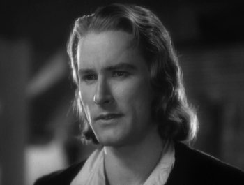 Movie still from “Captain Blood” (1935), directed by Michael Curtiz – Black and white photograph of a man with long blonde hair; Close Up shot, Over the shoulder angle