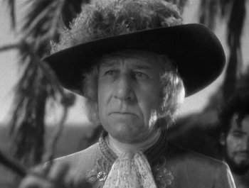 Movie still from “Captain Blood” (1935), directed by Michael Curtiz – An older man wearing a black hat and a white shirt; Close Up shot, Low angle