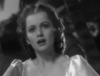 Movie still from “Captain Blood” (1935), directed by Michael Curtiz – A black - and - white photo of a woman in a white dress; Close Up shot, Low angle