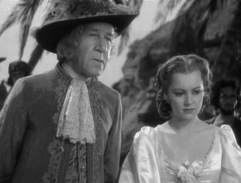 Movie still from “Captain Blood” (1935), directed by Michael Curtiz – An older man and a young woman standing next to each other; Medium shot, Low angle