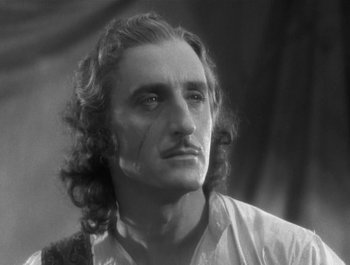 Movie still from “Captain Blood” (1935), directed by Michael Curtiz – A black and white photo of a man with long hair; Close Up shot, Low angle