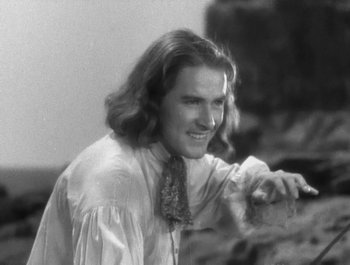 Movie still from “Captain Blood” (1935), directed by Michael Curtiz – A black and white photo of a man with long hair; Close Up shot, High angle