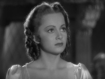 Movie still from “Captain Blood” (1935), directed by Michael Curtiz – A black - and - white photo of a woman in a dress; Close Up shot, High angle