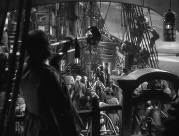 Movie still from “Captain Blood” (1935), directed by Michael Curtiz – A black and white photo of people on a boat; Wide shot, High angle