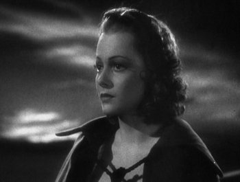 Movie still from “Captain Blood” (1935), directed by Michael Curtiz – A black - and - white photo of a woman in a cape; Close Up shot, High angle