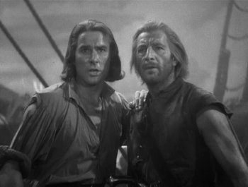 Movie still from “Captain Blood” (1935), directed by Michael Curtiz – A black - and - white photo of two men standing next to each other; Medium shot, Low angle