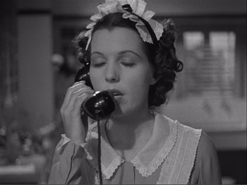 Movie still from “Captains Courageous” (1937), directed by Victor Fleming – A woman in a dress is talking on a phone; Close Up shot, High angle