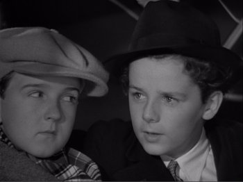 Movie still from “Captains Courageous” (1937), directed by Victor Fleming – Two young boys wearing hats and one of the boys is wearing a hat; Close Up shot, High angle