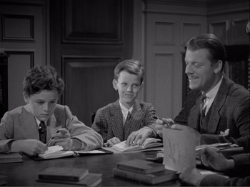 Movie still from “Captains Courageous” (1937), directed by Victor Fleming – A group of people sitting at a table with books; Medium shot, High angle