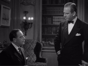 Movie still from “Captains Courageous” (1937), directed by Victor Fleming – Two men in suits are talking to each other in a living room; Medium shot, Over the shoulder angle