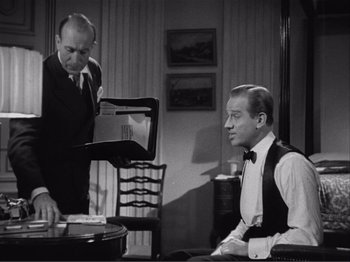 Movie still from “Captains Courageous” (1937), directed by Victor Fleming – A man in a suit and tie standing next to another man in a suit and tie; Medium shot, Over the shoulder angle