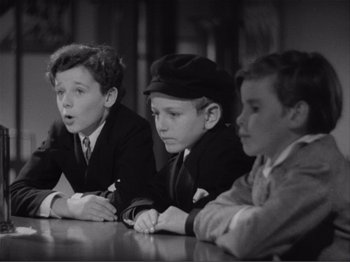 Movie still from “Captains Courageous” (1937), directed by Victor Fleming – A group of young men sitting at a table; Medium shot, High angle
