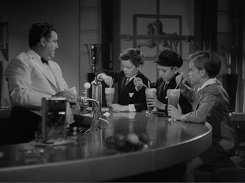 Movie still from “Captains Courageous” (1937), directed by Victor Fleming – A group of people sitting at a table with drinks; Medium shot, High angle