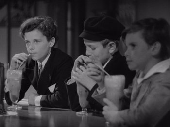 Movie still from “Captains Courageous” (1937), directed by Victor Fleming – A group of young men sitting at a table; Medium shot, High angle