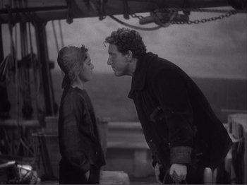 Movie still from “Captains Courageous” (1937), directed by Victor Fleming – A man and a woman are standing next to each other on a boat; Medium shot, Over the shoulder angle