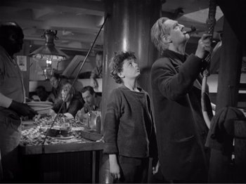 Movie still from “Captains Courageous” (1937), directed by Victor Fleming – A group of people sitting around a table; Medium shot, Low angle