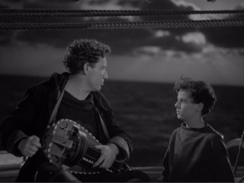 Movie still from “Captains Courageous” (1937), directed by Victor Fleming – A man and a boy on a boat in the ocean; Medium shot, High angle