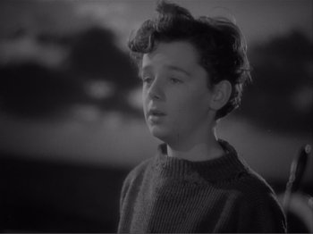 Movie still from “Captains Courageous” (1937), directed by Victor Fleming – A young boy in a sweater looking to his left; Close Up shot, High angle