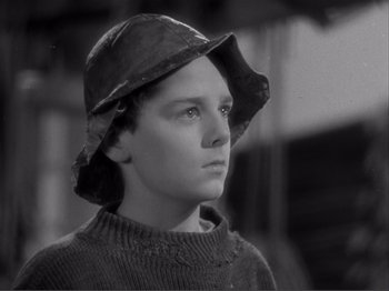 Movie still from “Captains Courageous” (1937), directed by Victor Fleming – A young man wearing a hat and sweater; Close Up shot, High angle
