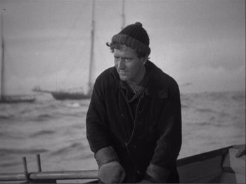 Movie still from “Captains Courageous” (1937), directed by Victor Fleming – A black and white photo of a man on a boat in the ocean; Medium shot, High angle