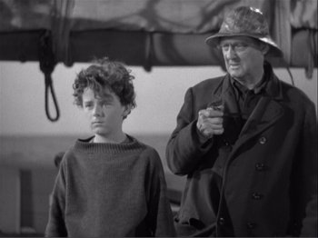 Movie still from “Captains Courageous” (1937), directed by Victor Fleming – An older man and a young boy standing next to each other; Medium shot, High angle