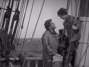Movie still from “Captains Courageous” (1937), directed by Victor Fleming – Two people standing on a boat in the ocean; Medium shot, High angle