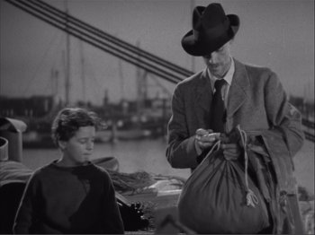 Movie still from “Captains Courageous” (1937), directed by Victor Fleming – A man and a boy looking at something in a bag; Medium shot, Low angle