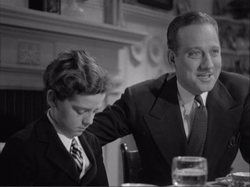 Movie still from “Captains Courageous” (1937), directed by Victor Fleming – An older man sitting next to a young boy; Medium shot, Low angle