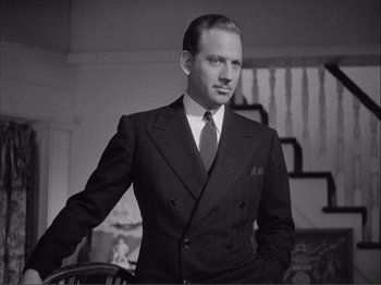 Movie still from “Captains Courageous” (1937), directed by Victor Fleming – A man in a suit and tie standing in a room; Medium shot, Low angle