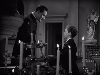 Movie still from “Captains Courageous” (1937), directed by Victor Fleming – Two men standing next to each other in front of candles; Medium shot, Low angle