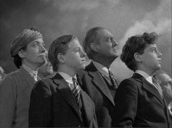 Movie still from “Captains Courageous” (1937), directed by Victor Fleming – A black and white photo of a group of people in suits; Medium shot, Low angle