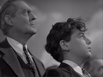 Movie still from “Captains Courageous” (1937), directed by Victor Fleming – An older man and a young boy looking up at something; Medium shot, Low angle