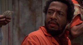 Movie still from “Car Wash” (1976), directed by Michael Schultz – A person wearing an orange shirt; Close Up shot, Low angle