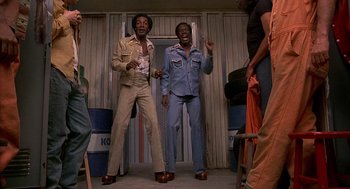 Movie still from “Car Wash” (1976), directed by Michael Schultz – A couple of men standing next to each other in a room; Medium shot, Low angle