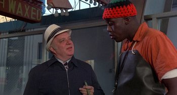 Movie still from “Car Wash” (1976), directed by Michael Schultz – A man wearing a hat talking to another man; Medium shot, Low angle