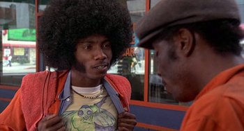 Movie still from “Car Wash” (1976), directed by Michael Schultz – A man with a big afro talking to another man; Medium shot, Over the shoulder angle