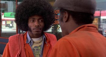 Movie still from “Car Wash” (1976), directed by Michael Schultz – A man in a red jacket and a man in a black hat; Close Up shot, Over the shoulder angle
