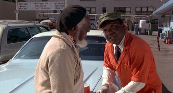 Movie still from “Car Wash” (1976), directed by Michael Schultz – Two older men talking to each other in a parking lot; Medium shot, Over the shoulder angle