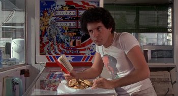 Movie still from “Car Wash” (1976), directed by Michael Schultz – A man sitting at a table with a plate of food; Medium shot, Low angle