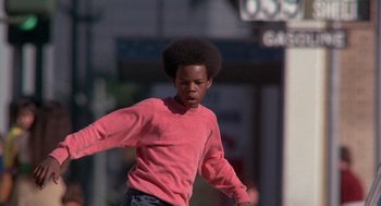Movie still from “Car Wash” (1976), directed by Michael Schultz – A young man in a pink shirt is playing frisbee; Medium shot, Low angle