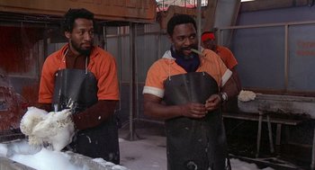 Movie still from “Car Wash” (1976), directed by Michael Schultz – A group of men standing next to each other in a building; Medium shot, Low angle