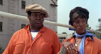Movie still from “Car Wash” (1976), directed by Michael Schultz – A man and a woman wearing orange shirts and hats; Close Up shot, Low angle