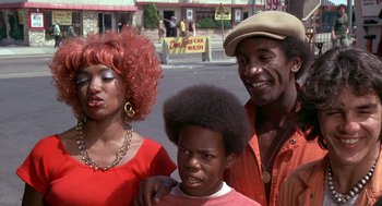 Movie still from “Car Wash” (1976), directed by Michael Schultz – A man and a woman standing next to a young boy; Medium shot, Low angle