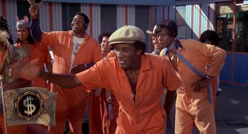 Movie still from “Car Wash” (1976), directed by Michael Schultz – A group of men in orange jumpsuits and hats; Medium shot, Low angle