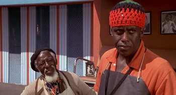 Movie still from “Car Wash” (1976), directed by Michael Schultz – Two men standing next to each other in front of a building; Close Up shot, Low angle