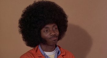 Movie still from “Car Wash” (1976), directed by Michael Schultz – A man with a large afro is posing for a picture; Close Up shot, Low angle