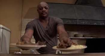 Movie still from “Car Wash” (1976), directed by Michael Schultz – A man in a kitchen holding a plate with food on top of it; Medium shot, Low angle