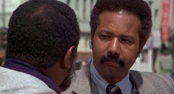 Movie still from “Car Wash” (1976), directed by Michael Schultz – A man in a suit talking to another man in a suit; Close Up shot, Over the shoulder angle