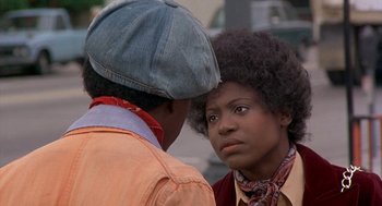 Movie still from “Car Wash” (1976), directed by Michael Schultz – Two people standing next to each other on the street; Close Up shot, Over the shoulder angle