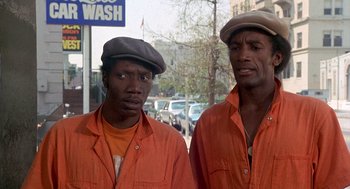 Movie still from “Car Wash” (1976), directed by Michael Schultz – A couple of men standing next to each other on the street; Close Up shot, Low angle